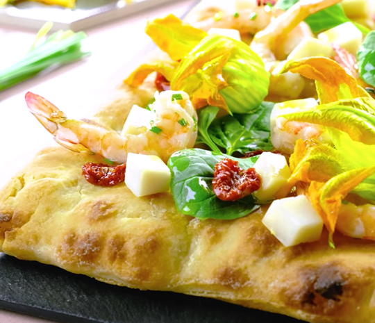 Focaccia farcita con Caprino alle Rose Officine Gastronomiche Spadoni, gamberi e fiori di zucca.